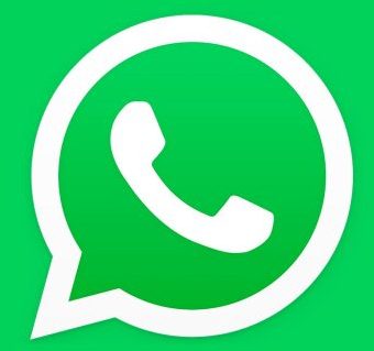 Top view of smartphone displaying WhatsApp logo on a wooden background, representing technology and communication.